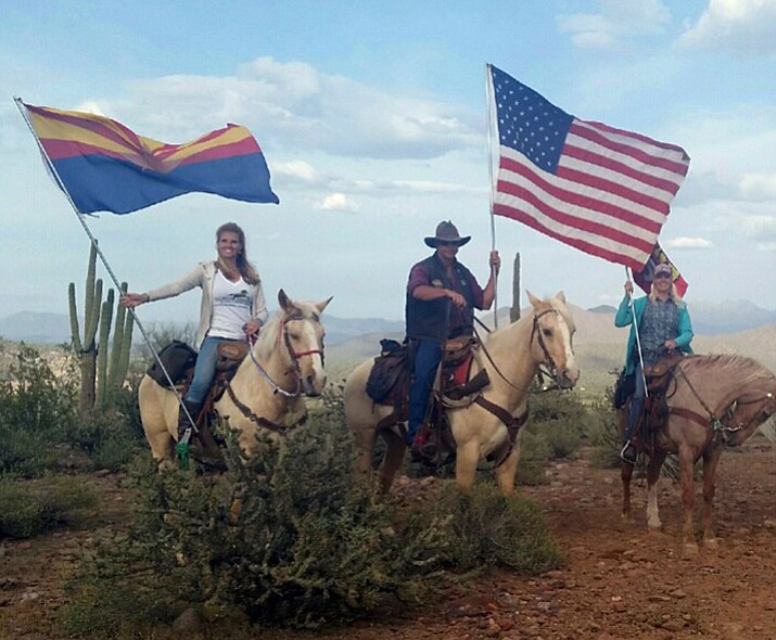 From left to right are Simone Netherlands, left, with Arizona flag, Mike McFadden, with American flag and his wife, Shannon, at Coon Bluff in the Tonto Forest. Netherlands is president of the Salt River Horse Management Group, which has been a key advocate in preserving the wild herd of Salt River horses. The state House cleared the final hurdle with a vote last week for a bill forwarded to Gov. Doug Ducey to protect the herd for future generations.