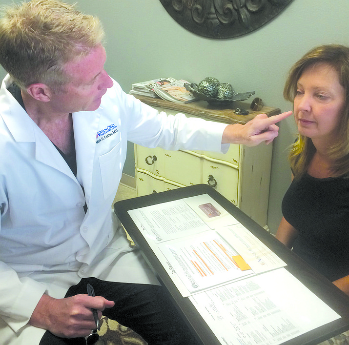 Dr. Mark Fetter, a plastic surgeon in Prescott, meets with a client about facial treatments.
