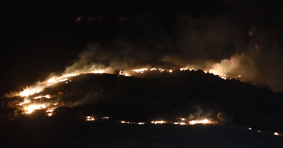Fire burns uphill as Central Arizona Fire, Truckee Hotshots and National Forest firefighters worked to contain a wildland fire northeast of Coyote Springs Road and Pronghorn Lane in Prescott Valley Thursday night. (Les Stukenberg/The Daily Courier)