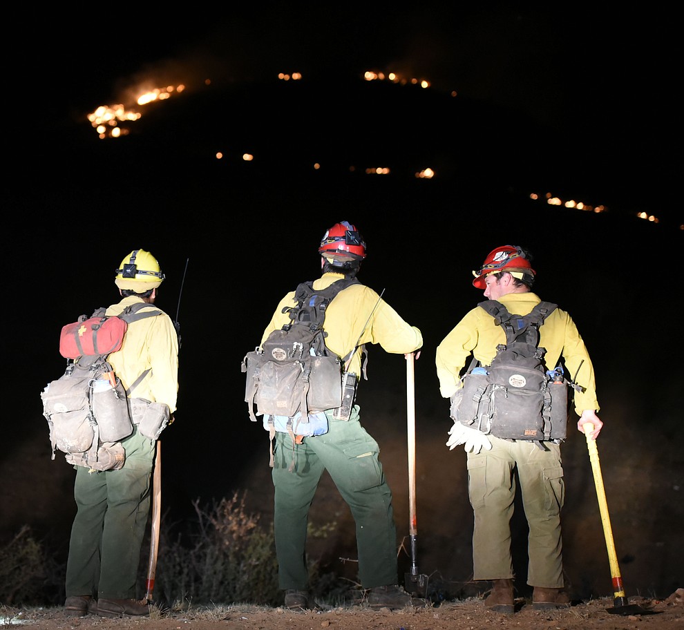 Truckee Hotshots watch the fire behavior before heading uphill as Central Arizona Fire, and National Forest firefighters worked to contain a wildland fire northeast of Coyote Springs Road and Pronghorn Lane in Prescott Valley Thursday night. (Les Stukenberg/The Daily Courier)