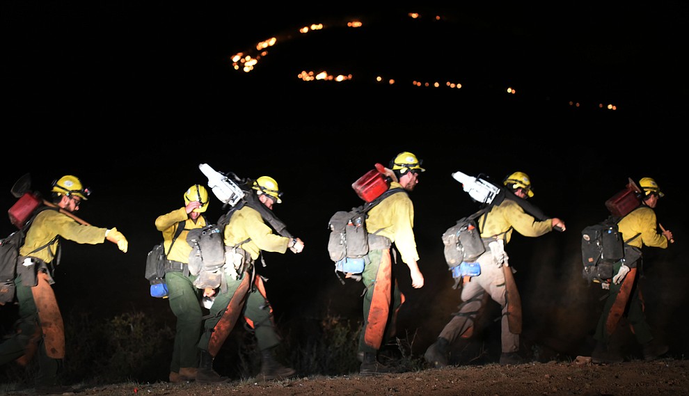 Members of the Truckee Hotshot crew head up the hill as they, Central Arizona Fire and National Forest firefighters worked to contain a wildland fire northeast of Coyote Springs Road and Pronghorn Lane in Prescott Valley Thursday night. (Les Stukenberg/The Daily Courier)