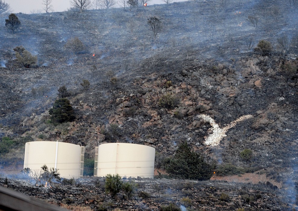 Fire burned around the water tanks and the Yarnell Y as it raced through the hills on the south side of Yarnell Wednesday afternoon. (Les Stukenberg/The Daily Courier)