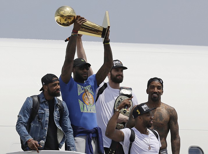 Cleveland Cavaliers’ LeBron James raises the trophy for the Cleveland fans, Monday, June 20, in Cleveland. 