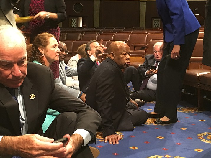 This photo provided by Rep. John Yarmuth, D-Ky., shows Democrat members of Congress, including Rep. John Lewis, D-Ga., center, and Rep. Joe Courtney, D-Conn., left, participate in sit-down protest seeking a a vote on gun control measures, Wednesday, June 22, 2016, on the floor of the House on Capitol Hill in Washington. 