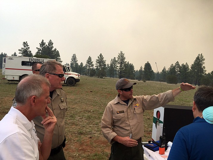 Navajo County Sheriff KC Clark, second from left, listens during a wildfire briefing from a U.S. Forest Service official on Fort Apache Indian Reservation, Ariz., on Thursday, June 16, 2016. Fire lines were holding Thursday in the fight against a wildfire threatening several communities with thousands of residents in east-central Arizona.