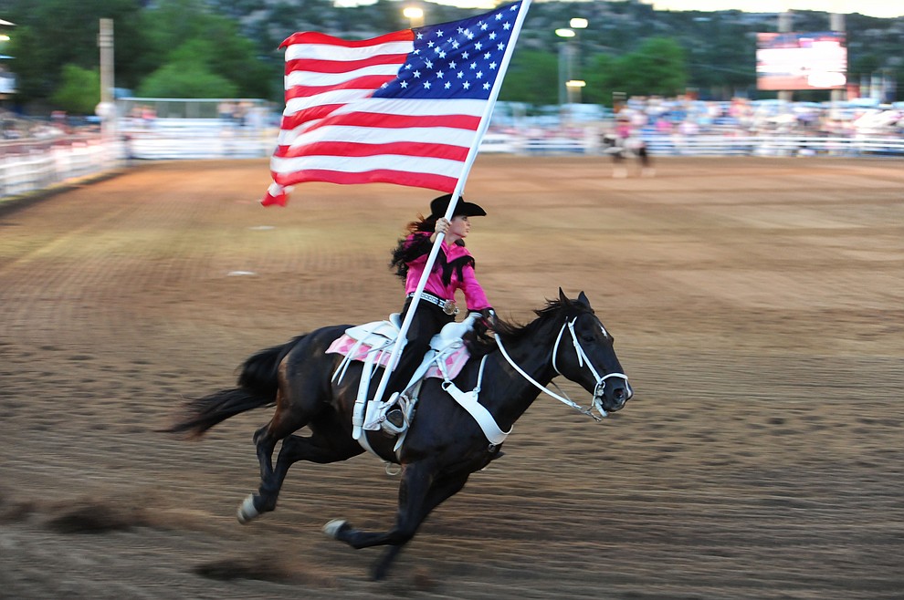 Bringing the American flag around the arena during the second round of the Prescott Frontier Days Rodeo Wednesday night. (Les Stukenberg/The Daily Courier)