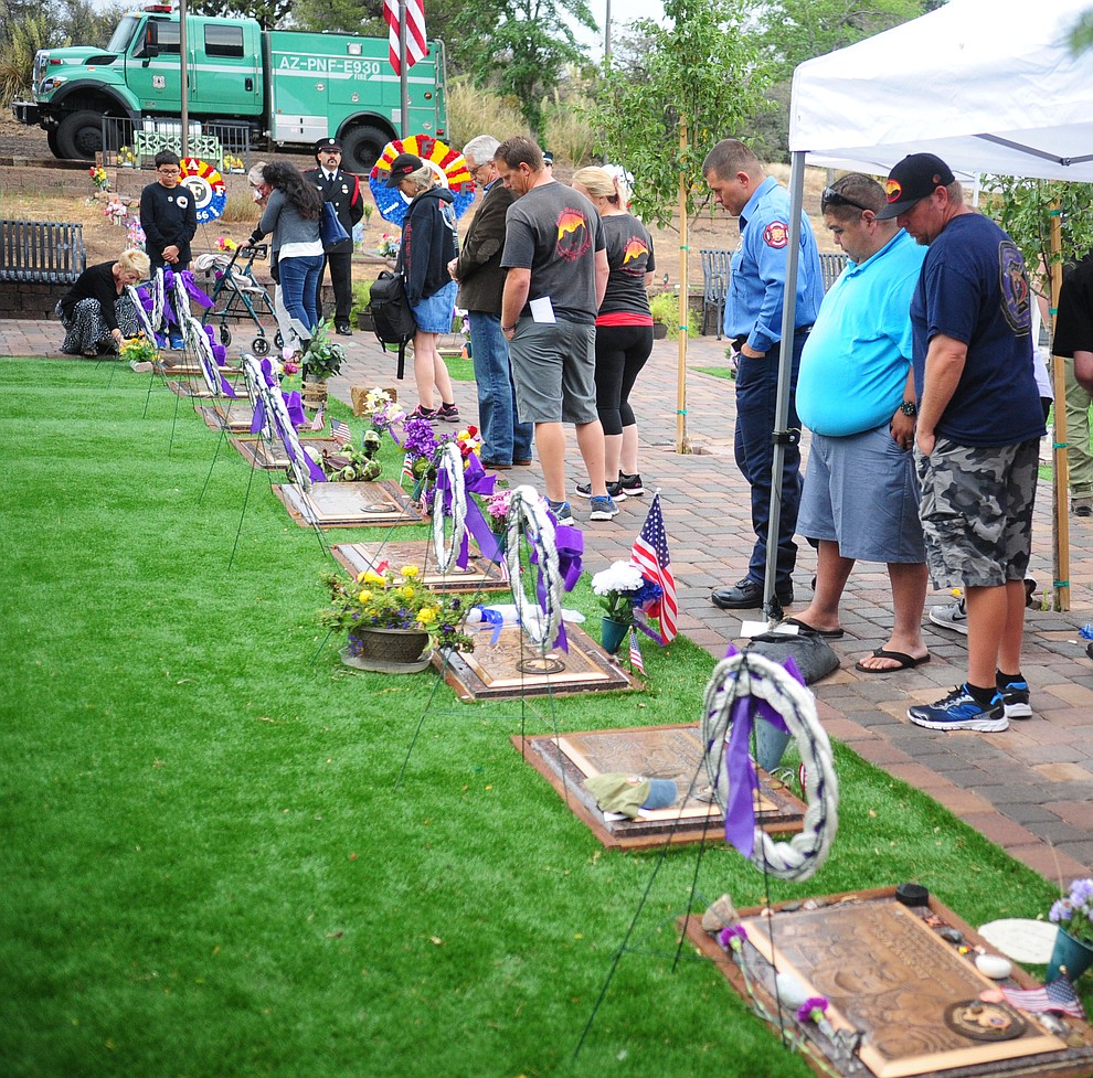 Family members, friends and coworkers pay their respects following a Celebration of Remembrance ceremony at the Arizona Pioneer's Home Cemetery on the third anniversary of the death's of the 19 Granite Mountain Hotshots while fighting the Yarnell Hill Fire. (Les Stukenberg/The Daily Courier)
