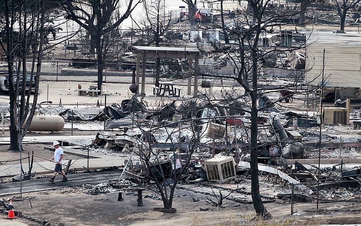 A worker walks past burned out mobile homes in South Lake, Calif., Tuesday, June 28, 2016, after a wildfire devastated the area.