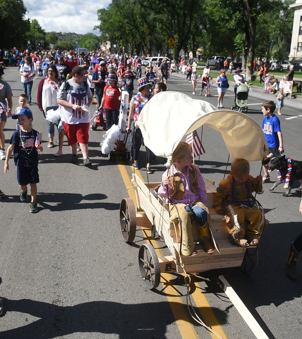 A covered wagon leads a mass of children down Cortez Street during the 75th annual Kiwanis Kiddie Parade through downtown Prescott Friday morning. (Les Stukenberg/The Daily Courier)