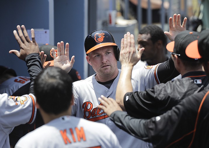 Baltimore Orioles' Mark Trumbo, center, is greeted by teammates after he scored on a double hit by Ryan Flaherty during the second inning against the Los Angeles Dodgers, Wednesday, July 6, in Los Angeles. 