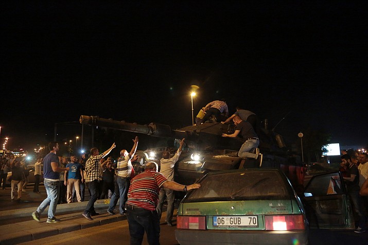 Tanks move into position as Turkish people attempt to stop them, in Ankara, Turkey, late Friday, July 15, 2016. Turkey's armed forces said it "fully seized control" of the country Friday and its president responded by calling on Turks to take to the streets in a show of support for the government. A loud explosion was heard in the capital, Ankara, fighter jets buzzed overhead, gunfire erupted outside military headquarters and vehicles blocked two major bridges in Istanbul.