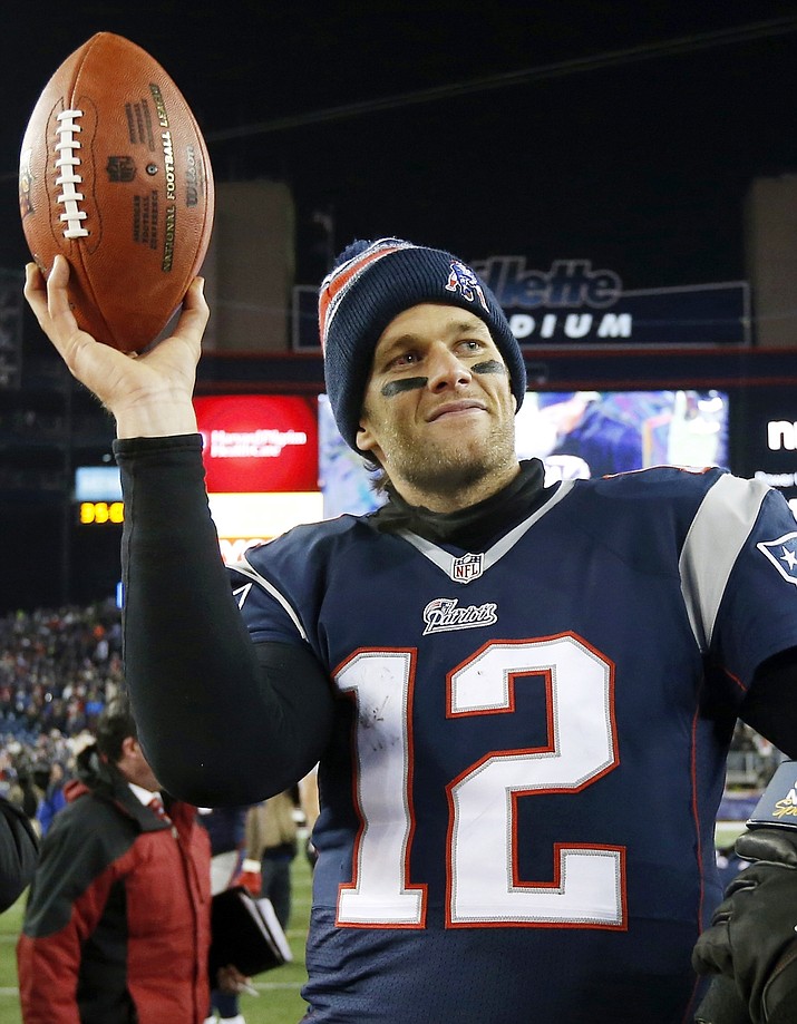 In this Jan. 10, 2015, file photo, New England Patriots quarterback Tom Brady holds up the game ball after an NFL playoff game against the Baltimore Ravens in Foxborough, Mass.