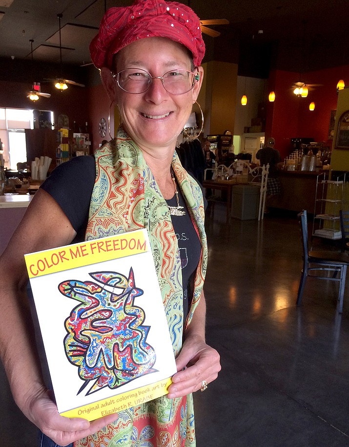 Elizabeth Urabe poses with the first of three published adult coloring books, Color Me Freedom. She is working on a fourth book for children called Kid Colors that will encourage introspection.
