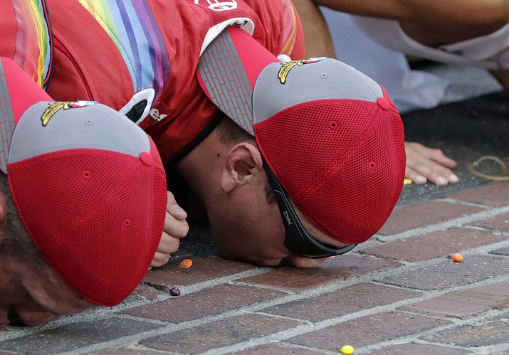 Kyle Busch, right, kisses the yard of brick at the start/finish line after winning the Brickyard 400 NASCAR auto race at Indianapolis Motor Speedway in Indianapolis, Sunday, July 24.
