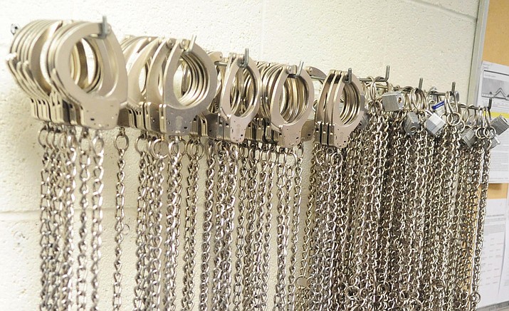 Full restraint shackles used during prisoner transportation hang on a wall of the county jail.