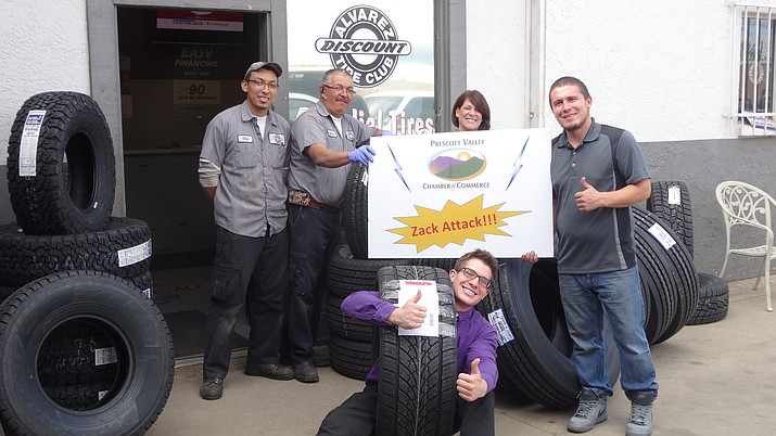 Zack Hurt (center) climbs inside a tire for a publicity photo during one of his Zack Attacks, this one at Alvarez Discount Tire Club. Hurt is leaving the Prescott Valley Chamber of Commerce to work with children in need. (Courtesy photo)
