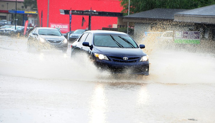 Cars travel through flowing water as downtown Prescott got hit with a heavy rainstorm just before noon on Wednesday.  (Les Stukenberg/The Daily Courier)