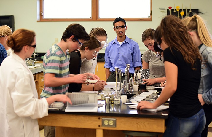 New Prescott High School teacher Todd Harris watches as chemistry students perform an experiment Monday afternoon. (Les Stukenberg/The Daily Courier)