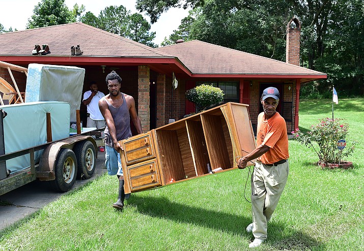 Brandon Scott, left, helps Dexter Smith move furniture out of his home after flooding Thursday, Aug. 18, 2016, in Crosby, Miss. Mississippi officials say heavy rains last week and through the weekend damaged roads in six counties in the southern part of the state.