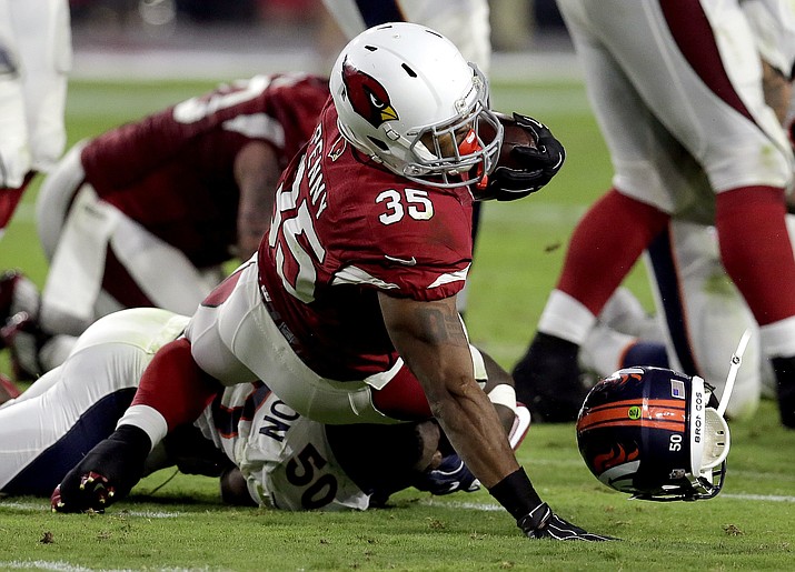 Denver Broncos linebacker Zaire Anderson (50) loses his helmet as he tackles Arizona Cardinals’ Elijhaa Penny (35) during the first half of an NFL preseason football game, Thursday, Sept. 1, in Glendale, Ariz.