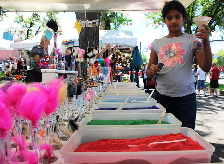 Aanya Mulpurii contemplates what color sands to layer her plastic bear figurine with at the event.