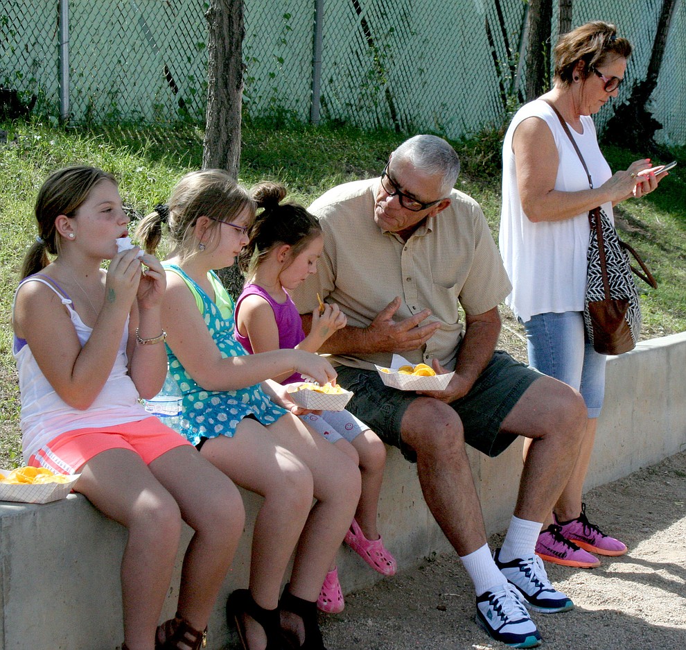 First-time fair-goers, from left, McKenna, 9, Maci, 8, Madelyn, 5, and grandparents Susan and Paul Hurley from Paulden, enjoy a nacho snack in the shade Saturday, Sept. 10, at the Yavapai County Fair. The Fair continues through Sunday.