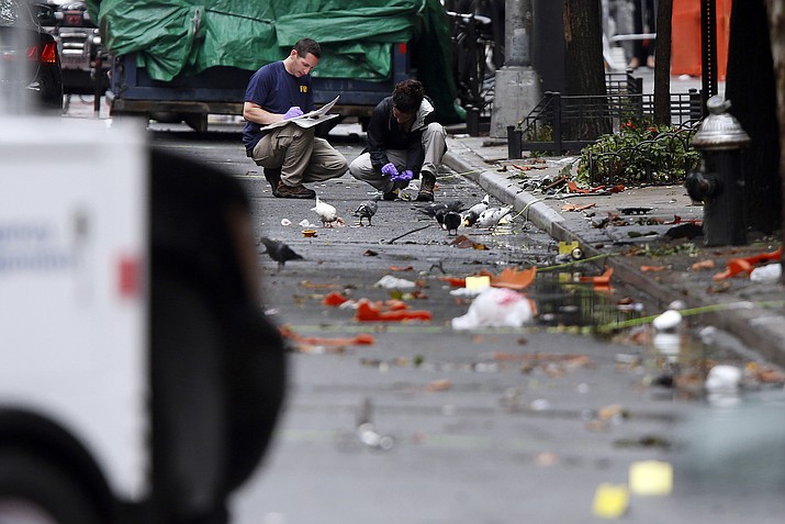 Evidence teams investigate at the scene of Saturday's explosion on West 23rd Street in Manhattan's Chelsea neighborhood, Monday, Sept. 19, 2016, in New York. Ahmad Khan Rahami, wanted in the bombings that rocked Chelsea and a New Jersey shore town was captured Monday after being wounded in a gun battle with police that erupted when he was discovered sleeping in a bar doorway, authorities said. 