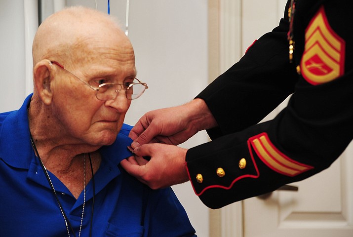 United State Marine Corps Staff Sgt. Jonathan Bush pins Korean War USMC veteran Robert “Bob” Mayer during a Granite Mountain Homecare and Hospice Veterans Honor Ceremony at his Prescott home.