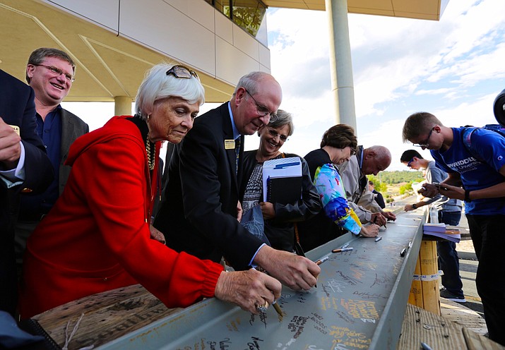 Interim President Dr. Karen Holbrook and Chancellor of Prescott Campus Dr. Frank Ayers sign a steel beam from the new STEM building at Embry-Riddle Aeronautical University, in Prescott on Sept. 29.