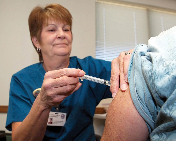 Darle Moulton, an RN with Yavapai County Community Health Services, administers a flu shot in Prescott Valley in October 2006.