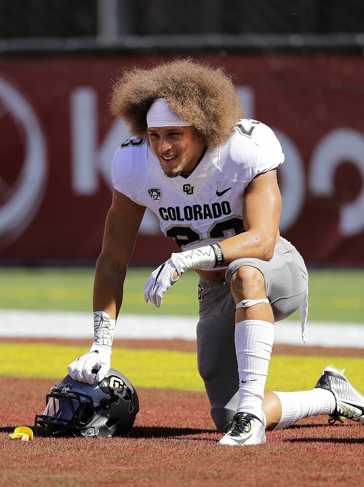 Colorado 's Phillip Lindsay kneels on the field during warmups before an NCAA college football game against Southern California in Los Angeles.  His nickname: Tasmanian Devil. His hair: Everywhere. His running style: A combination of the two.  The Colorado junior is a tailback who fell through the recruiting cracks, landed in Boulder and has emerged as a leader.