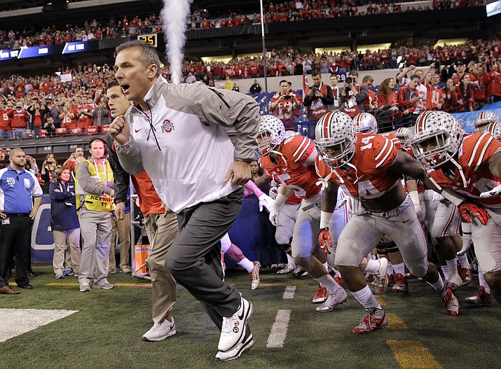 Ohio State head coach Urban Meyer runs onto the field with his team at the start of the 2014 Big Ten Conference championship NCAA college football game against Wisconsin in Indianapolis. If No. 1 Alabama and No. 2 Ohio State are going to lose this season, this would be an excellent week to do so. The Crimson Tide take on No. 9 Tennessee, while the Buckeyes take on No. 8 Wisconsin. 