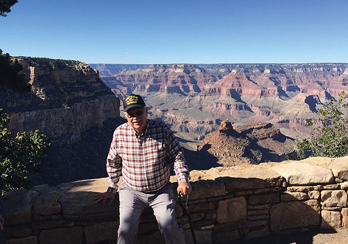 Don Follows sitting on railing on the South Rim of the Grand Canyon where in 1965 he got his first permanent assignment as a National Parks Service ranger; Follows spent almost 35 years working for both the National Parks Service and other state and federal land agencies in roles of ranger, geologist, ecologist, interpretative naturalist, photographer and more. 
