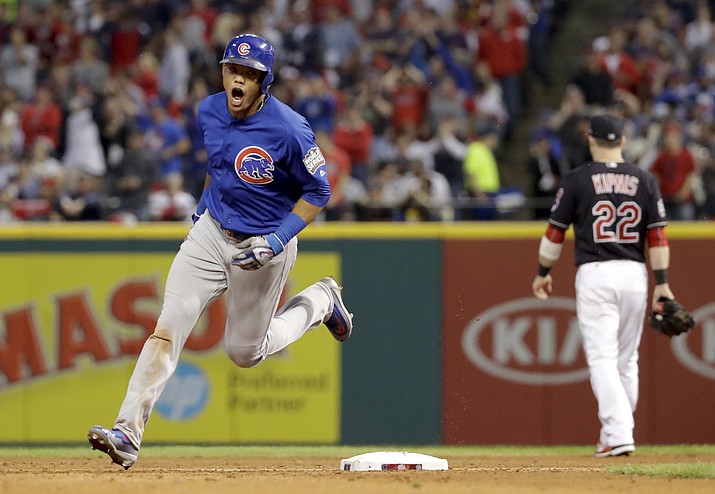 Chicago Cubs’ Addison Russell celebrates while rounding the bases after hitting a grand slam against the Cleveland Indians in the third inning of Game 6 on Tuesday in Cleveland.