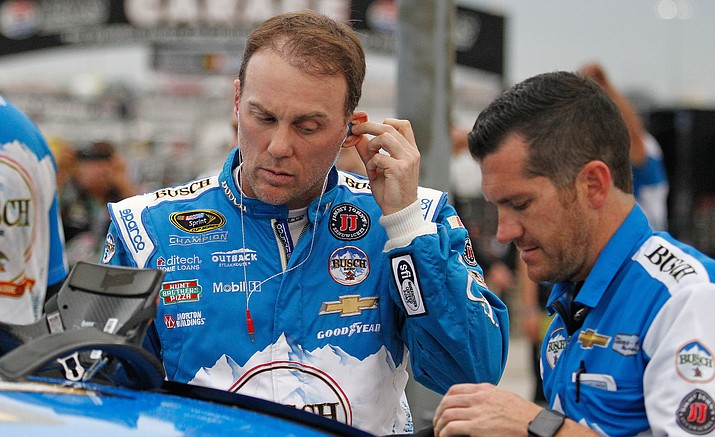 Kevin Harvick puts his radio earpieces in before qualifying for Sunday's NASCAR Sprint Cup auto race at Texas Motor Speedway, Friday, Nov. 4.