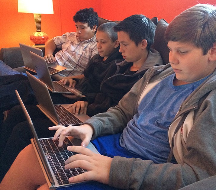 Four seventh-grade boys work on an essay in Wendy Tollefsen’s experimental classroom.