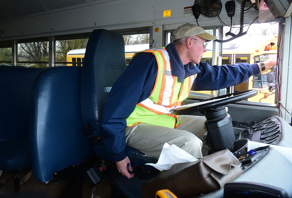 Prescott Unified School District Transportation Department's field trip and route coordinator Paul Beaumont checks his bus before going out on the afternoon run for route 11 Thursday, Dec. 1 in Prescott. (Les Stukenberg/The Daily Courier)