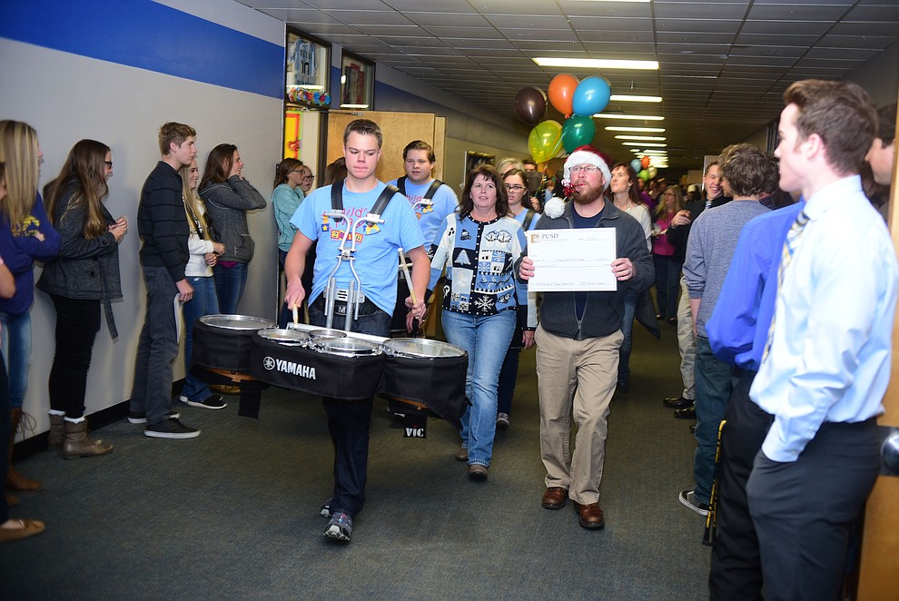 Prescott Unified School District Superintendent Joe Howard leads a drumline and members of the Prescott Education Foundation through Prescott High School as they went around on Friday, December 9 to district schools and handed out checks to teachers who had applied and received grants for special projects. (Les Stukenberg/The Daily Courier)