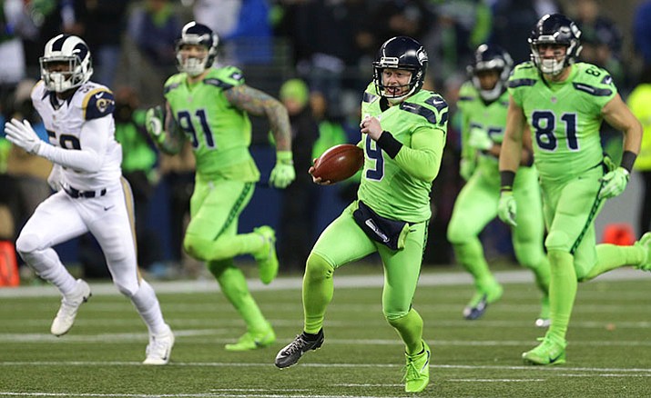 Seattle Seahawks punter Jon Ryan runs the ball after a fake punt against the Los Angeles Rams in the second half of an NFL football game, Thursday, Dec. 15, in Seattle. Ryan was injured on the play and left the game.