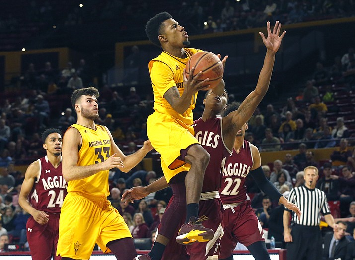 Arizona State’s Shannon Evans II, center, shoots against New Mexico State in Tempe on Saturday.