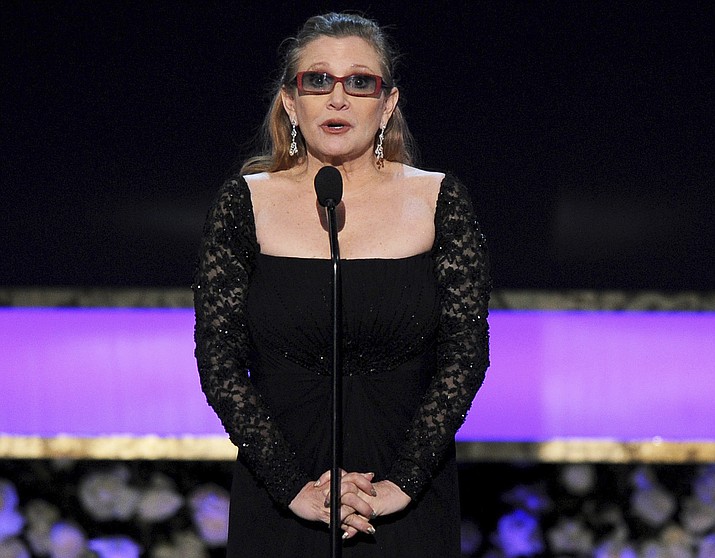 In this 2015 file photo, Carrie Fisher presents the life achievement award on stage at the 21st annual Screen Actors Guild Awards at the Shrine Auditorium in Los Angeles. Fisher has reportedly been transported to a hospital after suffering a severe medical emergency on a flight Friday, Dec. 23, 2016.