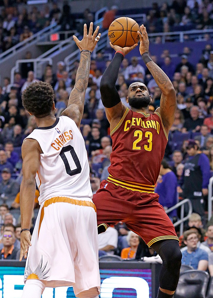 Cleveland Cavaliers forward LeBron James, right, shoots over Phoenix Suns forward Marquese Chriss during the first half Sunday, Jan. 8, in Phoenix.
