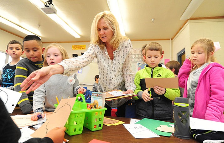 Coyote Springs Elementary School second-grade teacher Yvonne Berry hands out project materials during class Monday in Prescott Valley. Gov. Doug Ducey is expected on Friday to include raises for teachers in his budget.