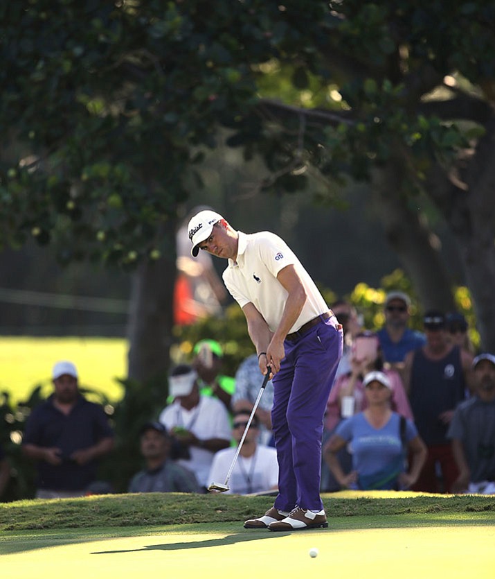 With a gallery behind him, Justin Thomas putts on the third green during the second round of the Sony Open golf tournament, Friday, Jan. 13, in Honolulu. 
