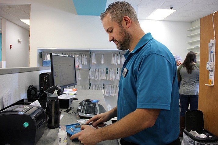 Jason Dykstra, pharmacist and owner of Chino Valley Pharmacy, fills a prescription.  