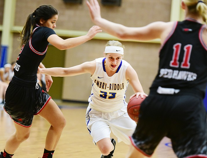 Embry Riddle’s Jenna Knudson (33) drives through a pair of defenders as the Eagles take on Simpson University on Thursday, Jan. 26, in Prescott. (Les Stukenberg/The Daily Courier)