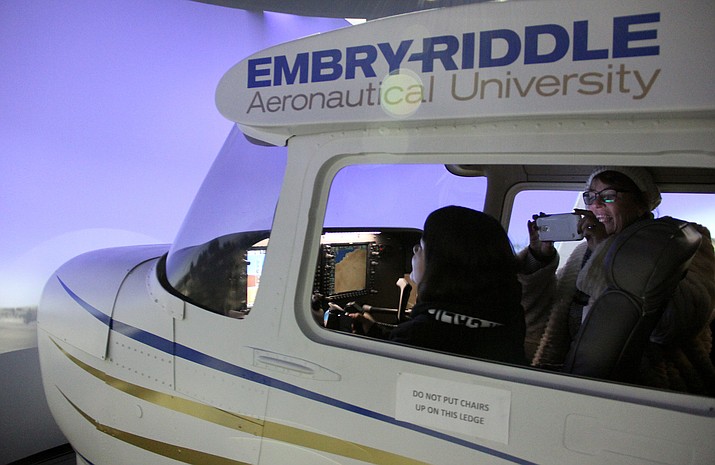 Edie Anderson (right) and her little, Ashley, try out a flight simulator at Embry-Riddle Aeronautical University’s flight training facility in Prescott Saturday, Jan. 28. 
