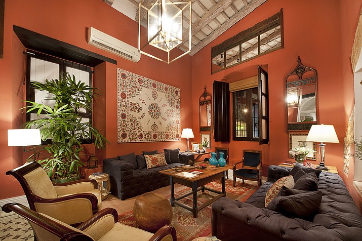 This undated photo provided by The Monacelli Press shows the Casas Del XVI in the Dominican Republic. The space is a great example of how to make a bold color statement work for real life. The conversation-starting poppy red hue avoids being overwhelming by pairing it with shades of brown. The photo is featured in the book "Hotel Chic at Home" by Sara Bliss. (The Monacelli Press via AP)