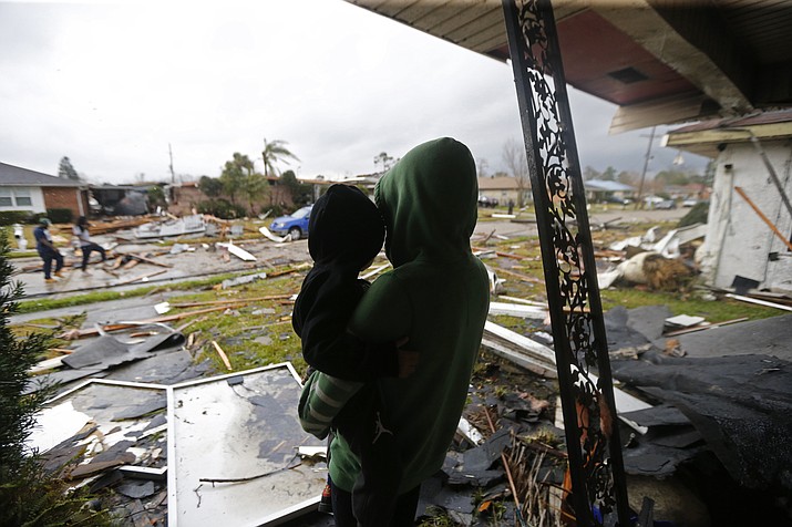 Eshon Trosclair holds her son Camron Chapital after a tornado tore through home while they were inside Tuesday, Feb. 7, 2017 in the eastern part of New Orleans.  The National Weather Service says at least three confirmed tornadoes have touched down, including one inside the New Orleans city limits. Buildings have been damaged and power lines are down. (AP Photo/Gerald Herbert)