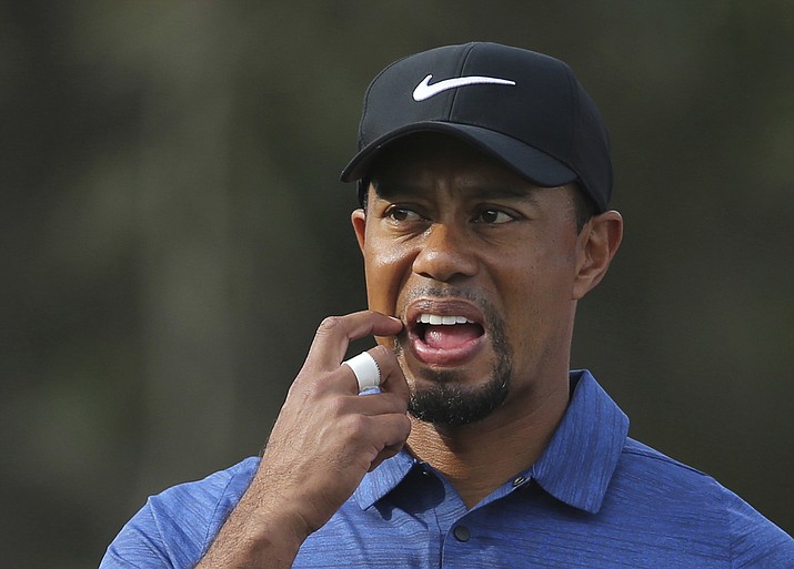 In this Feb. 2 photo, Tiger Woods reacts on hole 11th during the 1st round of the Dubai Desert Classic golf tournament in Dubai, United Arab Emirates. Tiger Woods has withdrawn from the Dubai Desert Classic with an apparent back injury after shooting an opening-round 5-over 77. (Kamran Jebreili/Associated Press)